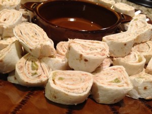 refried beans combined with seasoning and chiles, wrapped into tortillas and sliced into roll ups. Similar to a burrito, but bite sized